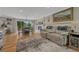 Open-concept living room with hardwood floors, a fireplace, and deck access at 25694 Stansbery St, Conifer, CO 80433