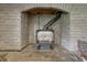 Close up of a classic wood stove in brick surround with metal flue at 25694 Stansbery St, Conifer, CO 80433