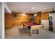 Finished basement with wood paneling, fireplace, and a pool table for entertainment at 5030 Cedar Way, Elizabeth, CO 80107