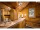 Bright wood paneled bathroom features a double sink vanity and a window with a view to the outdoors at 5030 Cedar Way, Elizabeth, CO 80107