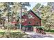 A-frame home has wood siding and a green metal roof nestled among trees, with a stone retaining wall at 5030 Cedar Way, Elizabeth, CO 80107