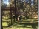 Outdoor greenhouse with clear roof and windows surrounded by mature trees and a lush green lawn at 5030 Cedar Way, Elizabeth, CO 80107