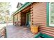 Inviting front porch with wood planks, log siding, and a decorative pot at 5030 Cedar Way, Elizabeth, CO 80107