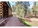 Spacious yard features a wooden deck with stone borders and bench seating among trees at 5030 Cedar Way, Elizabeth, CO 80107