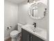 Modern bathroom features vanity with a gray cabinet, modern faucet, and a round decorative mirror at 5285 S Jericho Way, Centennial, CO 80015