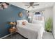 Stylish bedroom featuring a blue accent wall, decorative fixtures, and natural light at 5285 S Jericho Way, Centennial, CO 80015