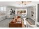 Bright living room with a comfortable brown leather sofa, large window and stylish built-in shelving at 5285 S Jericho Way, Centennial, CO 80015