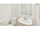 Clean, modern half bathroom with pedestal sink, toilet, and crisp white walls, offering functionality at 5780 N Killarney Way, Aurora, CO 80019