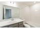 Clean bathroom with white tiling, a shower-tub combo, and a single sink vanity at 5780 N Killarney Way, Aurora, CO 80019