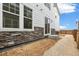 Home exterior featuring stone accents, a sliding glass door, and a fenced yard at 5780 N Killarney Way, Aurora, CO 80019