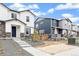 Exterior shot of white and blue homes, with new landscaping and adjacent driveways on a sunny day at 5780 N Killarney Way, Aurora, CO 80019