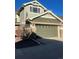 Two-car garage featuring a green door, stone accents, and visible house number at 15063 E Crestridge Dr, Centennial, CO 80015