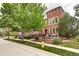 Inviting brick townhome with a manicured lawn and mature trees lining the sidewalk at 800 Rockhurst Dr # D, Highlands Ranch, CO 80129