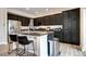 Well-appointed kitchen with dark cabinetry, stainless steel appliances, and an island with bar seating at 800 Rockhurst Dr # D, Highlands Ranch, CO 80129