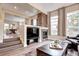 Open-concept living room with a brick fireplace, hardwood floors, and neutral walls at 800 Rockhurst Dr # D, Highlands Ranch, CO 80129