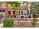 Charming brick townhome with a cozy front porch featuring seating and landscaping at 800 Rockhurst Dr # D, Highlands Ranch, CO 80129