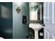 Elegant powder room with a pedestal sink, gold mirror, and decorative wall accents at 800 Rockhurst Dr # D, Highlands Ranch, CO 80129