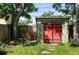 View of backyard shed with red doors and stepping stone path through manicured lawn at 361 Elati St, Denver, CO 80223