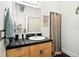 Well-lit bathroom with black countertops, modern fixtures, and a shower with patterned curtain at 361 Elati St, Denver, CO 80223