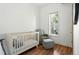 Bright and airy Bedroom with a crib, chair, ottoman and a window with light filtering blinds at 361 Elati St, Denver, CO 80223