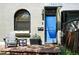 A inviting exterior showcasing a blue front door and sitting area with a chair and side table at 361 Elati St, Denver, CO 80223