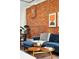 Cozy living space with a exposed brick wall, hardwood flooring, and comfortable furnishings at 361 Elati St, Denver, CO 80223