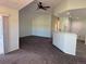 An open-concept living room boasts vaulted ceilings, carpet flooring and a pass-through to the kitchen for easy entertaining at 7777 S Biloxi Way, Aurora, CO 80016