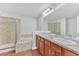 Well-lit bathroom with double sinks, a soaking tub, and a separate glass-enclosed shower at 8943 Tappy Toorie Cir, Highlands Ranch, CO 80129