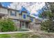 Inviting townhome featuring charming stone accents, covered entry, and landscaped front yard at 8943 Tappy Toorie Cir, Highlands Ranch, CO 80129