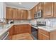 Beautiful kitchen featuring wooden cabinetry, stainless steel appliances, and tiled backsplash at 8943 Tappy Toorie Cir, Highlands Ranch, CO 80129