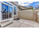 Stone patio features stone facade with sliding glass doors and privacy fence at 8943 Tappy Toorie Cir, Highlands Ranch, CO 80129