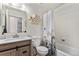 Bright bathroom features modern sink, commode, tub, and a shower with floral shower curtain at 6436 S Kline St, Littleton, CO 80127