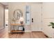 Bright and airy entryway with a round mirror, console table, and wood floors at 6437 Saddlesmith St, Castle Pines, CO 80108