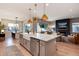 Modern kitchen with island, stainless steel appliances, and farmhouse sink at 6437 Saddlesmith St, Castle Pines, CO 80108