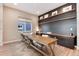 Home office with built-in shelving, desks, and wood-look flooring at 6437 Saddlesmith St, Castle Pines, CO 80108