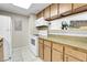 Galley kitchen with white appliances and wooden cabinetry at 18302 E Kepner Pl # 207, Aurora, CO 80017