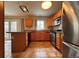 Open kitchen featuring stainless steel appliances, a breakfast bar, and wood cabinetry at 438 N Parkside Dr # C, Longmont, CO 80501