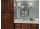 Bathroom featuring marble topped vanity, large mirror, sconce lighting and cabinet storage at 2365 S Holly Pl, Denver, CO 80222