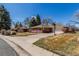 A brick ranch-style home with a basketball hoop, a driveway, and a two-car garage at 2365 S Holly Pl, Denver, CO 80222