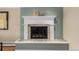 Close-up of the fireplace, which includes tile, a white mantle, and decorative objects at 2365 S Holly Pl, Denver, CO 80222