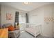 Cozy Bedroom features a recliner, window, and a white baby crib with cute pink patterned bedding at 9150 W 94Th Ave, Westminster, CO 80021
