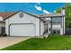 Charming two-story home featuring a white exterior, well-manicured lawn, and attached two-car garage at 9150 W 94Th Ave, Westminster, CO 80021