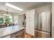 Open kitchen and dining area with stainless steel appliances, modern cabinetry, and abundant natural light at 9150 W 94Th Ave, Westminster, CO 80021