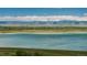 Expansive lake view with mountains in the background and community in the distance at 9150 W 94Th Ave, Westminster, CO 80021