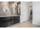 Modern bathroom with double vanity, unique mirrors, stylish lighting, and a doorway to the walk-in closet at 6674 Fonder Villa Dr, Parker, CO 80134