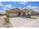 Charming exterior of the home with a well-manicured lawn and a two-car garage at 6674 Fonder Villa Dr, Parker, CO 80134