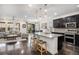 Well-lit kitchen includes an island, stainless steel appliances, dark cabinetry, and an open floor plan at 6674 Fonder Villa Dr, Parker, CO 80134