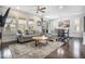 Bright living room with hardwood floors, large windows, stylish furniture, and access to the dining room at 6674 Fonder Villa Dr, Parker, CO 80134