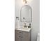 Stylish bathroom featuring an arched mirror, sleek vanity, modern fixtures, and elegant design elements at 5467 W Hinsdale Pl, Littleton, CO 80128