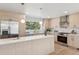 Well-lit kitchen with white countertops, stainless steel appliances, and ample cabinet space at 5467 W Hinsdale Pl, Littleton, CO 80128